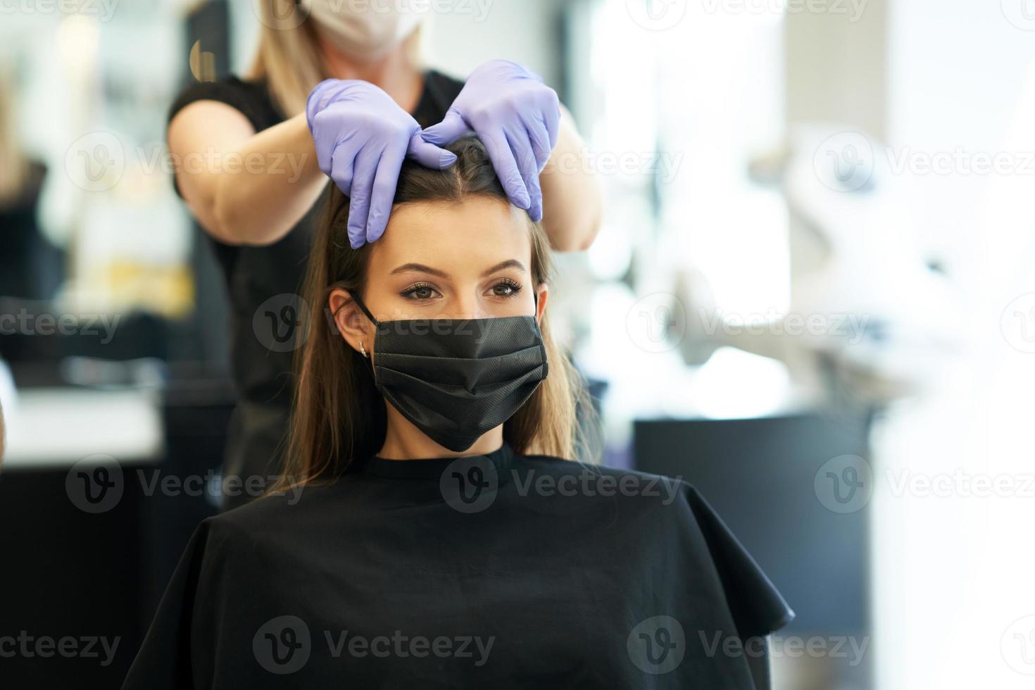 volwassen vrouw Bij kapper vervelend beschermend masker ten gevolge naar coronavirus pandemisch foto