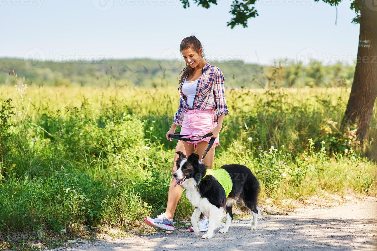 portret van gelukkig vrouw wandelen haar hond Bij vrije tijd foto