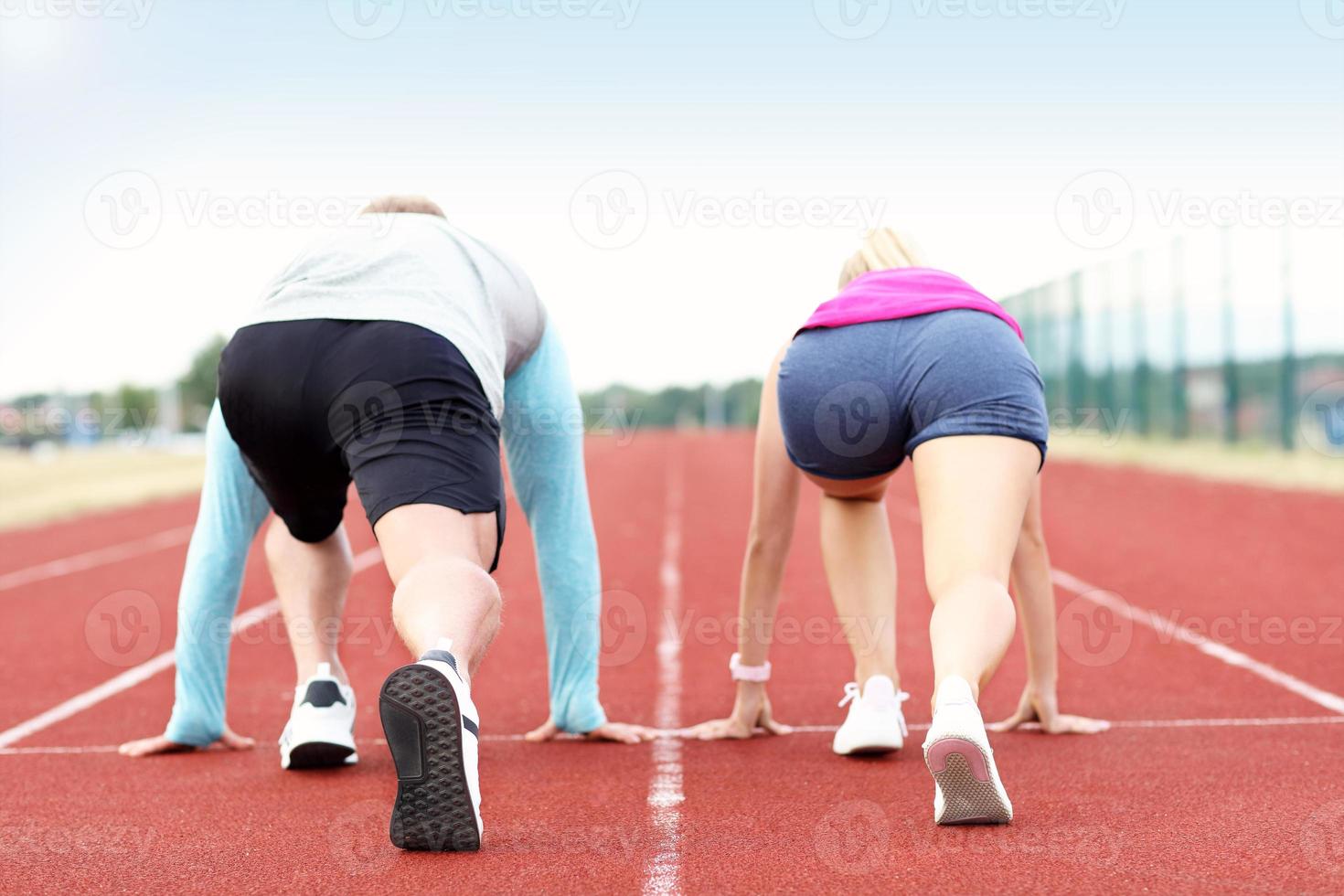 Mens en vrouw racing Aan buitenshuis bijhouden foto