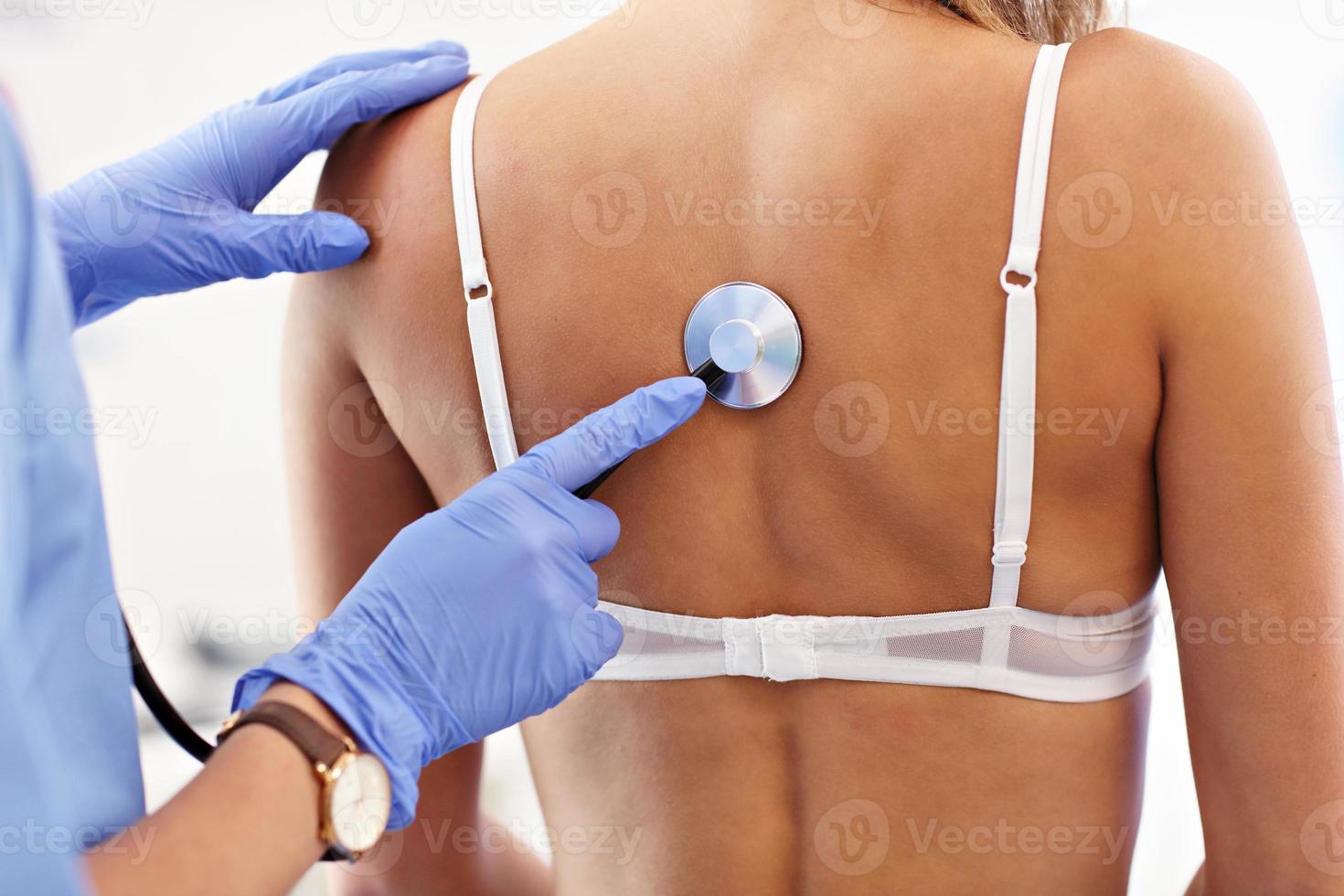 volwassen vrouw wezen onderzocht met stethoscoop door vrouw dokter foto