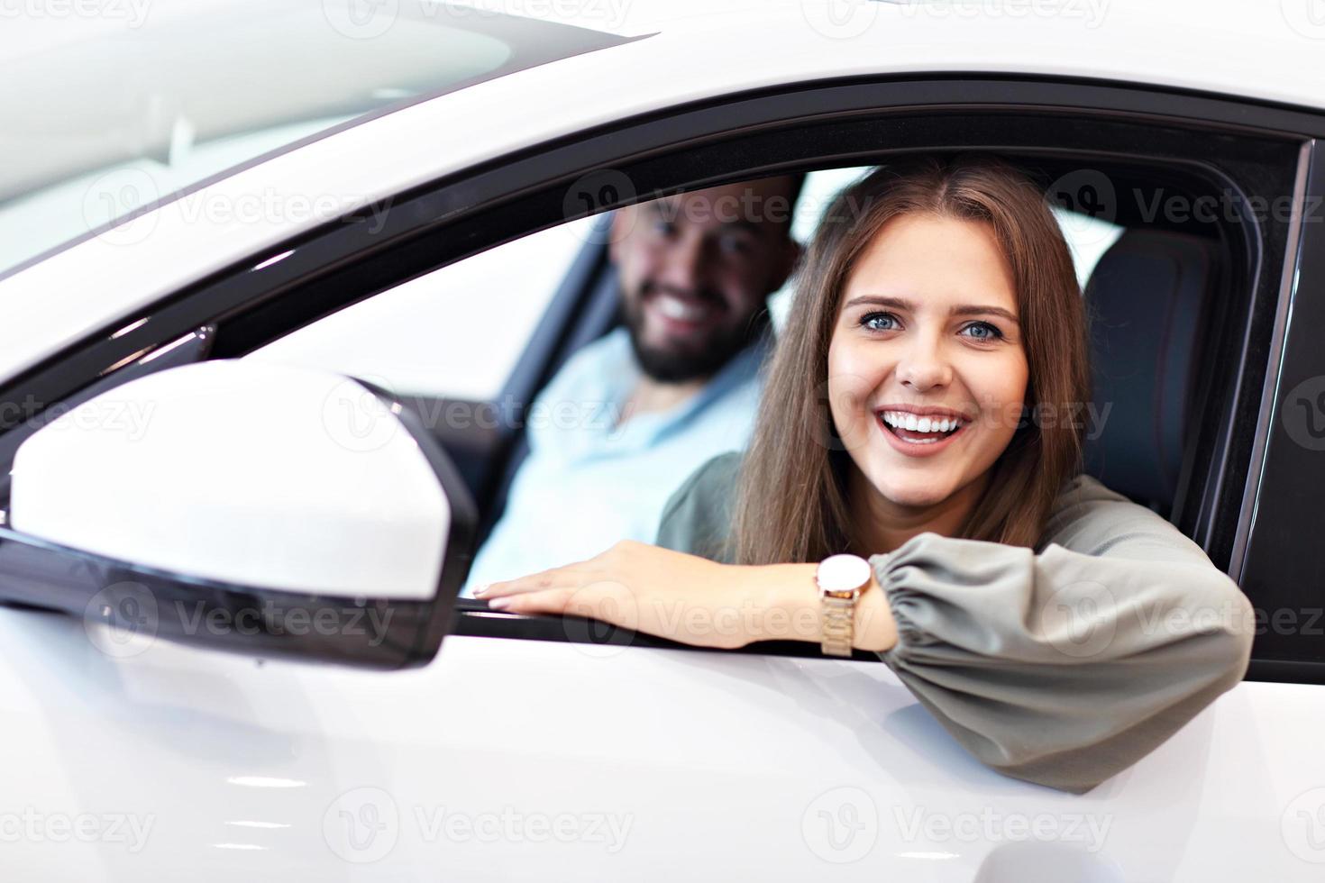 volwassen paar kiezen nieuw auto in toonzaal foto