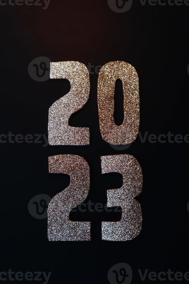 gelukkig nieuw jaar 2023. gouden getallen Aan een zwart achtergrond met schitteren foto