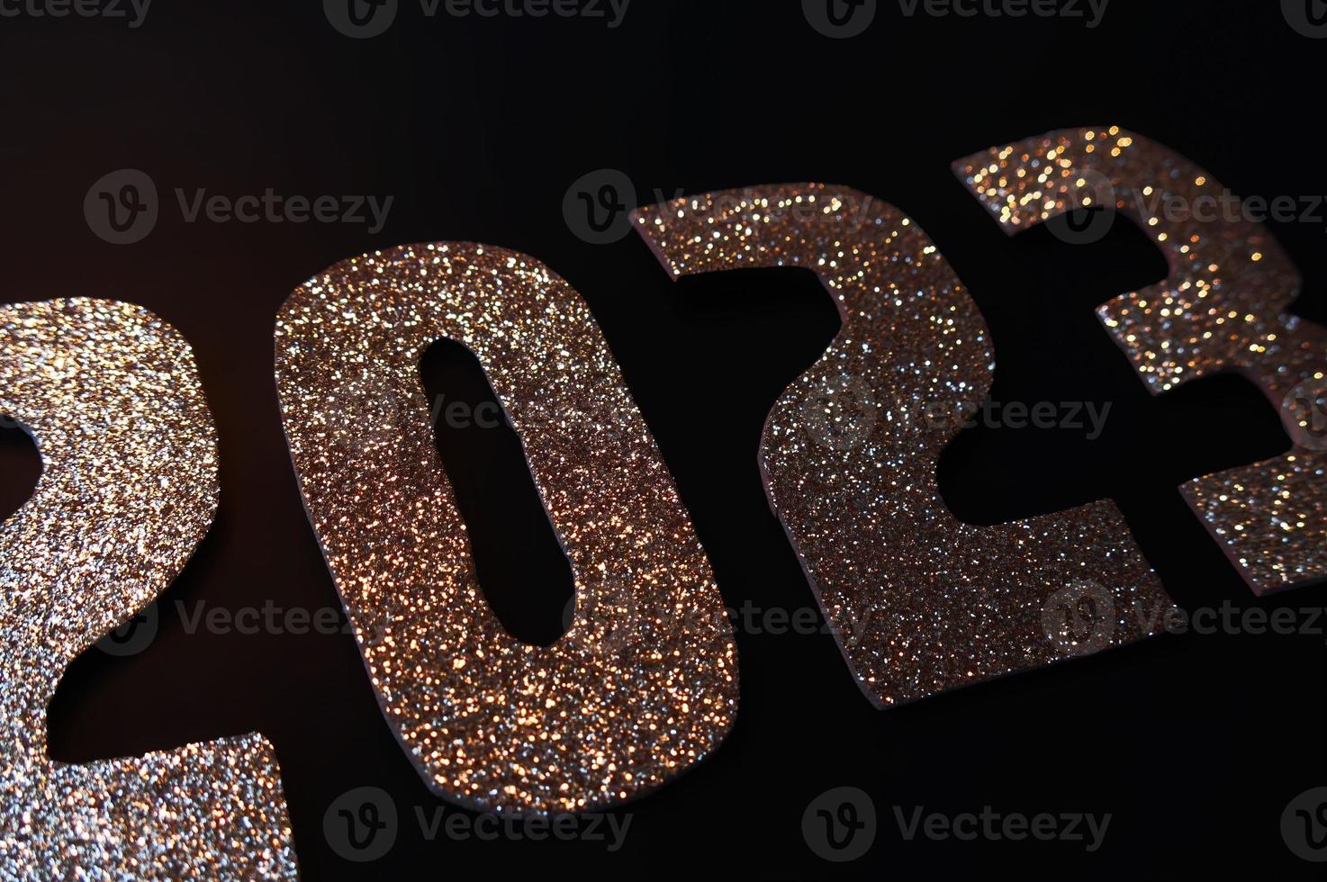 gelukkig nieuw jaar 2023. gouden getallen Aan een zwart achtergrond met schitteren foto