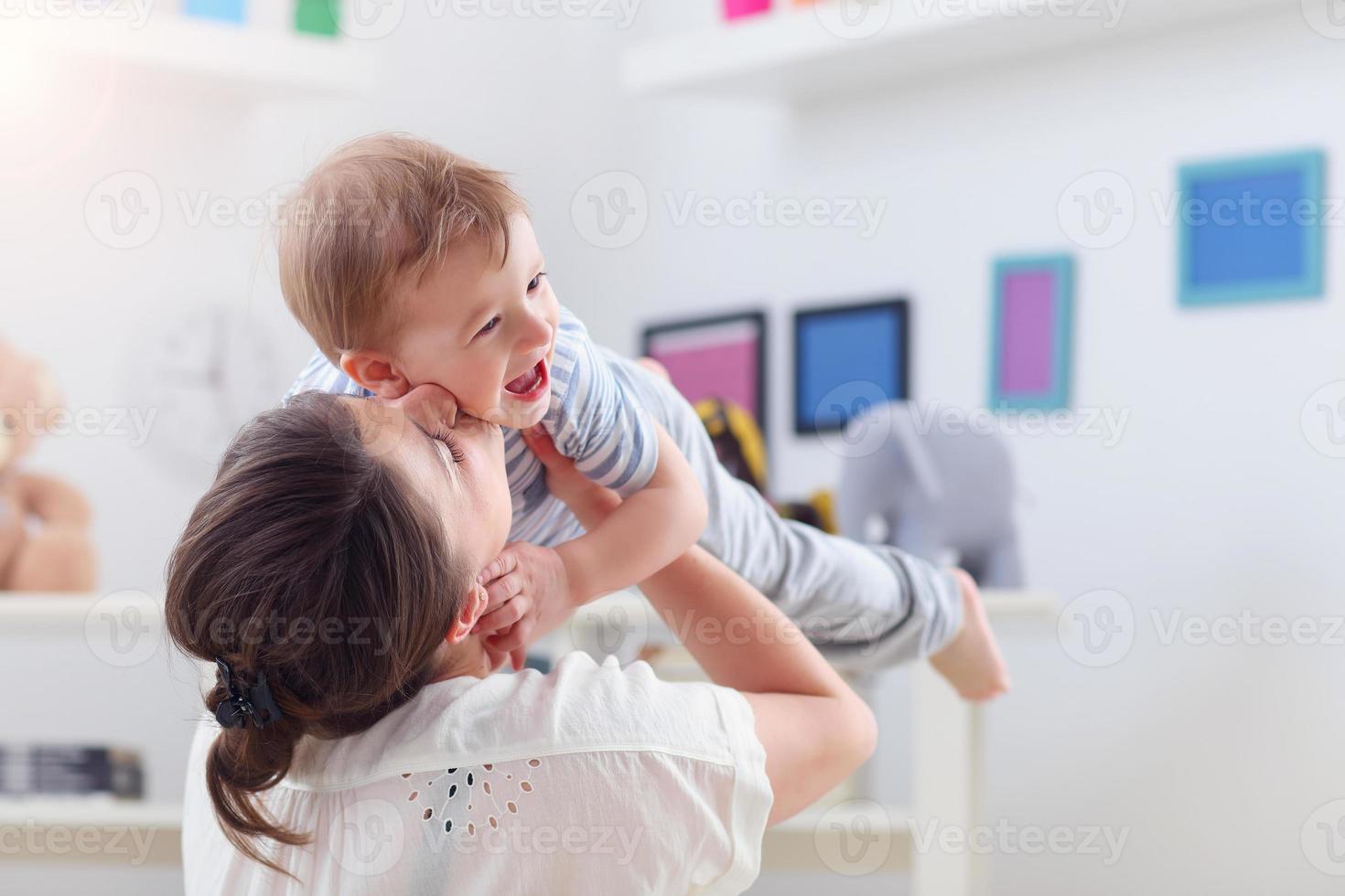 gelukkig moeder spelen met baby jongen Bij huis foto