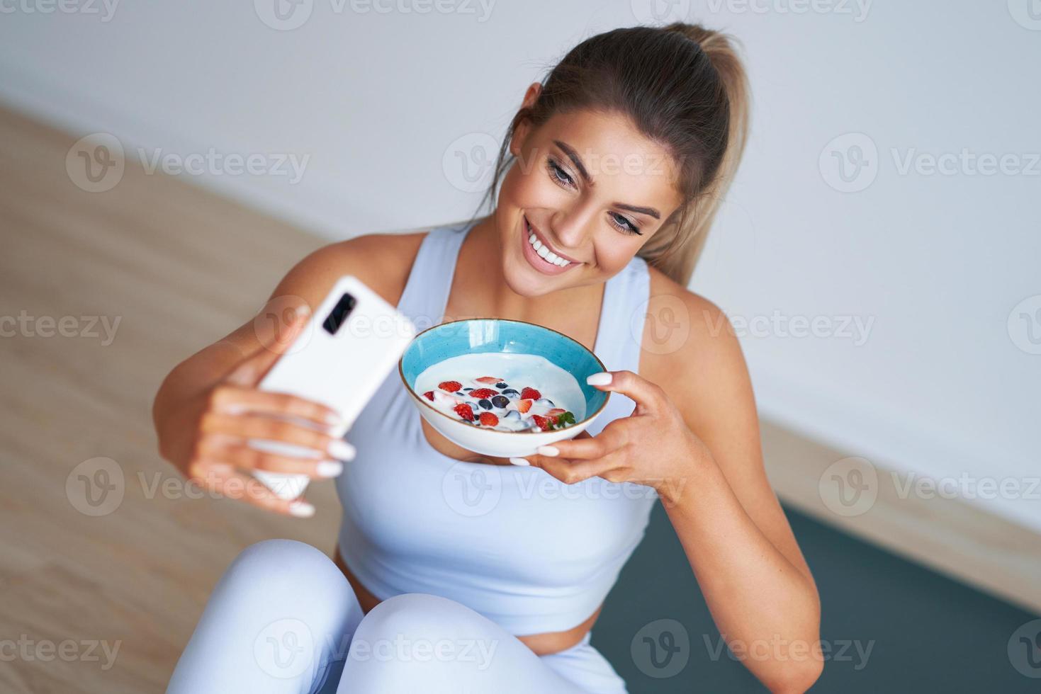 portret van mooi spaans vrouw aan het eten yoghurt bevorderen gezond levensstijl foto