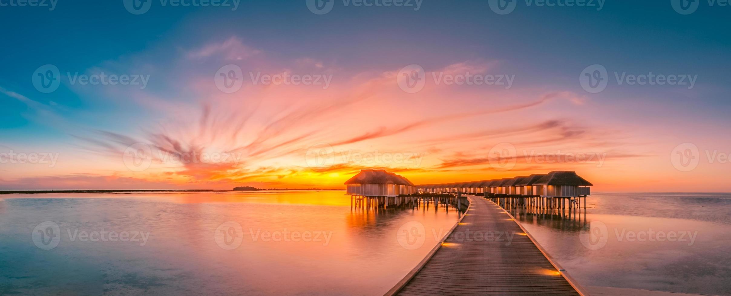 verbazingwekkend zonsondergang panorama Bij Maldiven. luxe toevlucht villa's zeegezicht met zacht LED lichten onder kleurrijk lucht. Maldiven zonsondergang zeegezicht visie. horizon met zee en kleurrijk lucht. geweldig zonsondergang landschap foto