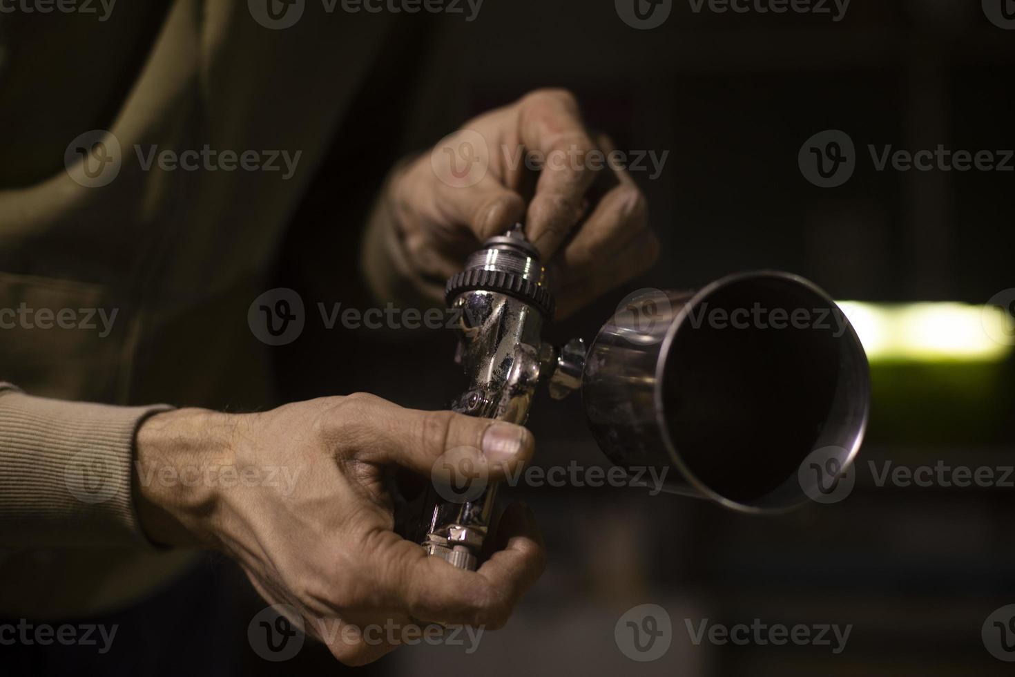 handen houden kogel. verf sproeier. verchroomd voorwerp. verstuiven hulpmiddel. foto