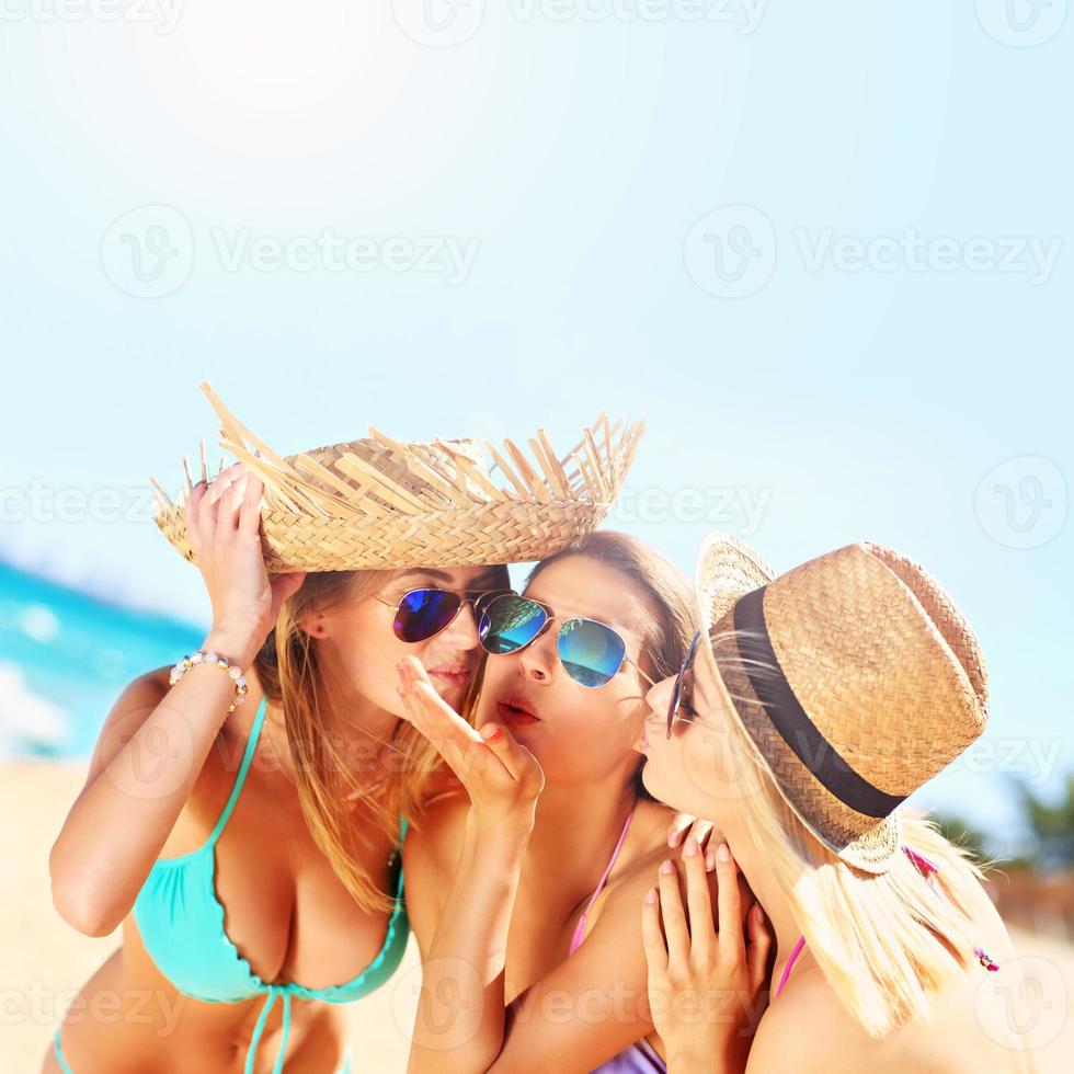 twee Dames zoenen vriend Aan de strand foto