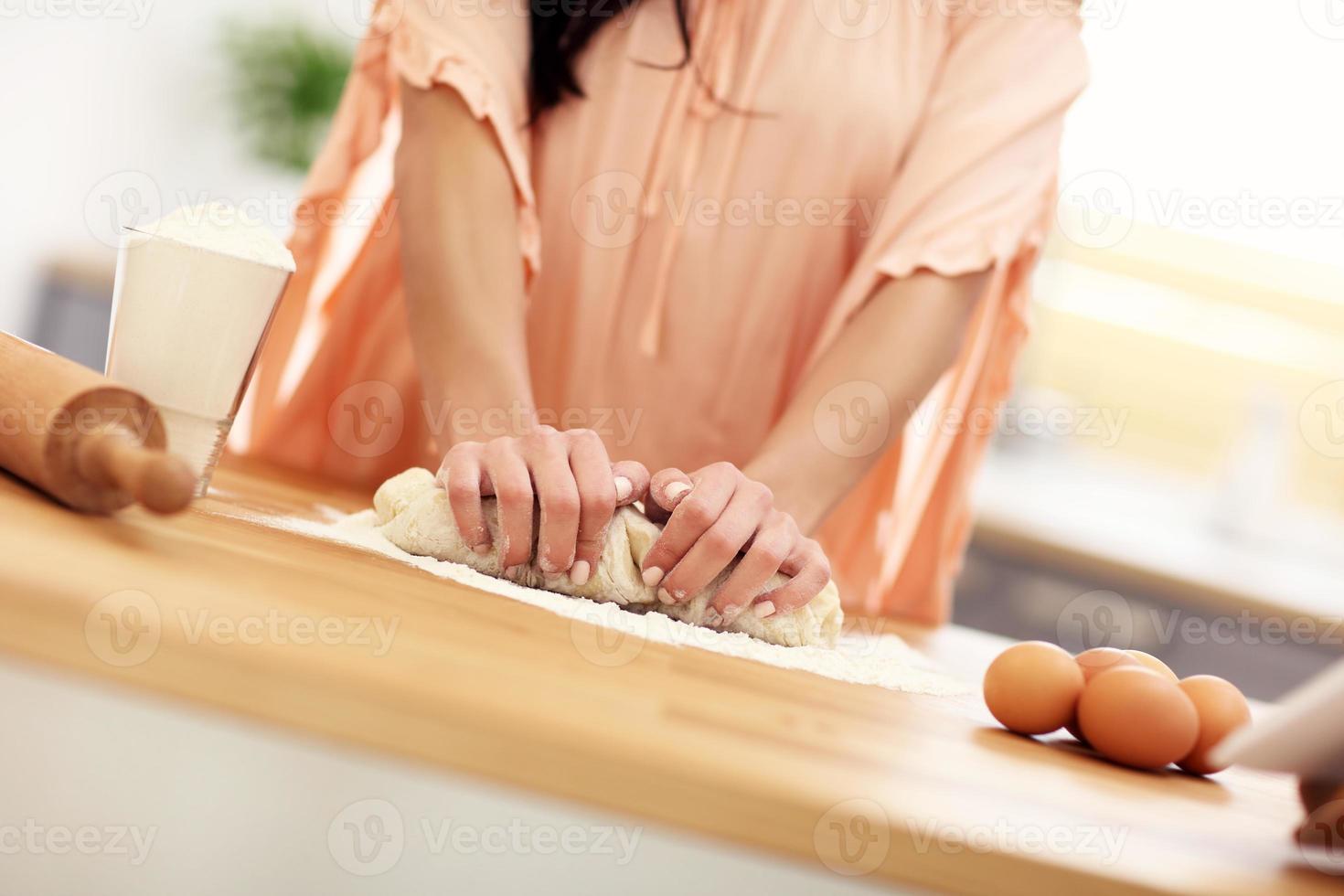 jong vrouw proberen naar koken iets in keuken foto