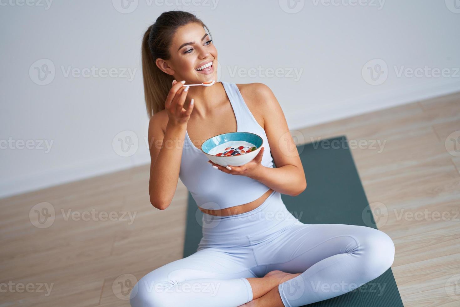 portret van mooi spaans vrouw aan het eten yoghurt bevorderen gezond levensstijl foto