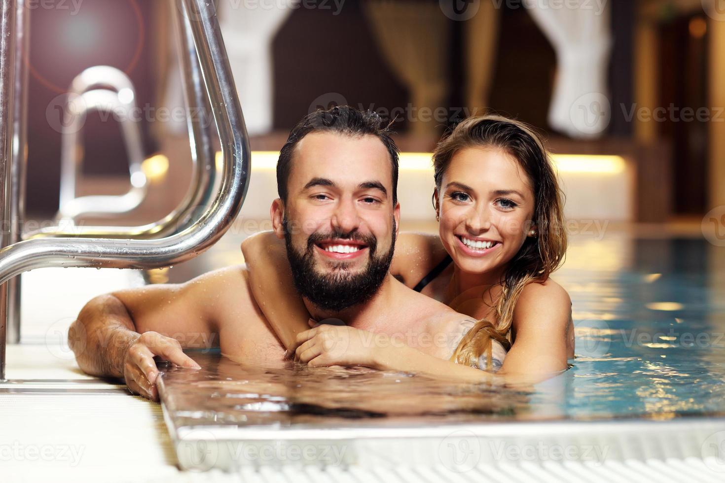 gelukkig paar ontspannende in zwembad spa foto