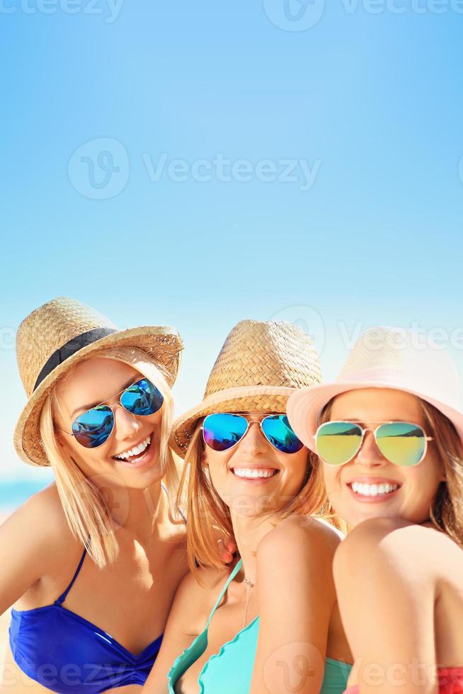 groep van Dames hebben pret Aan de strand foto