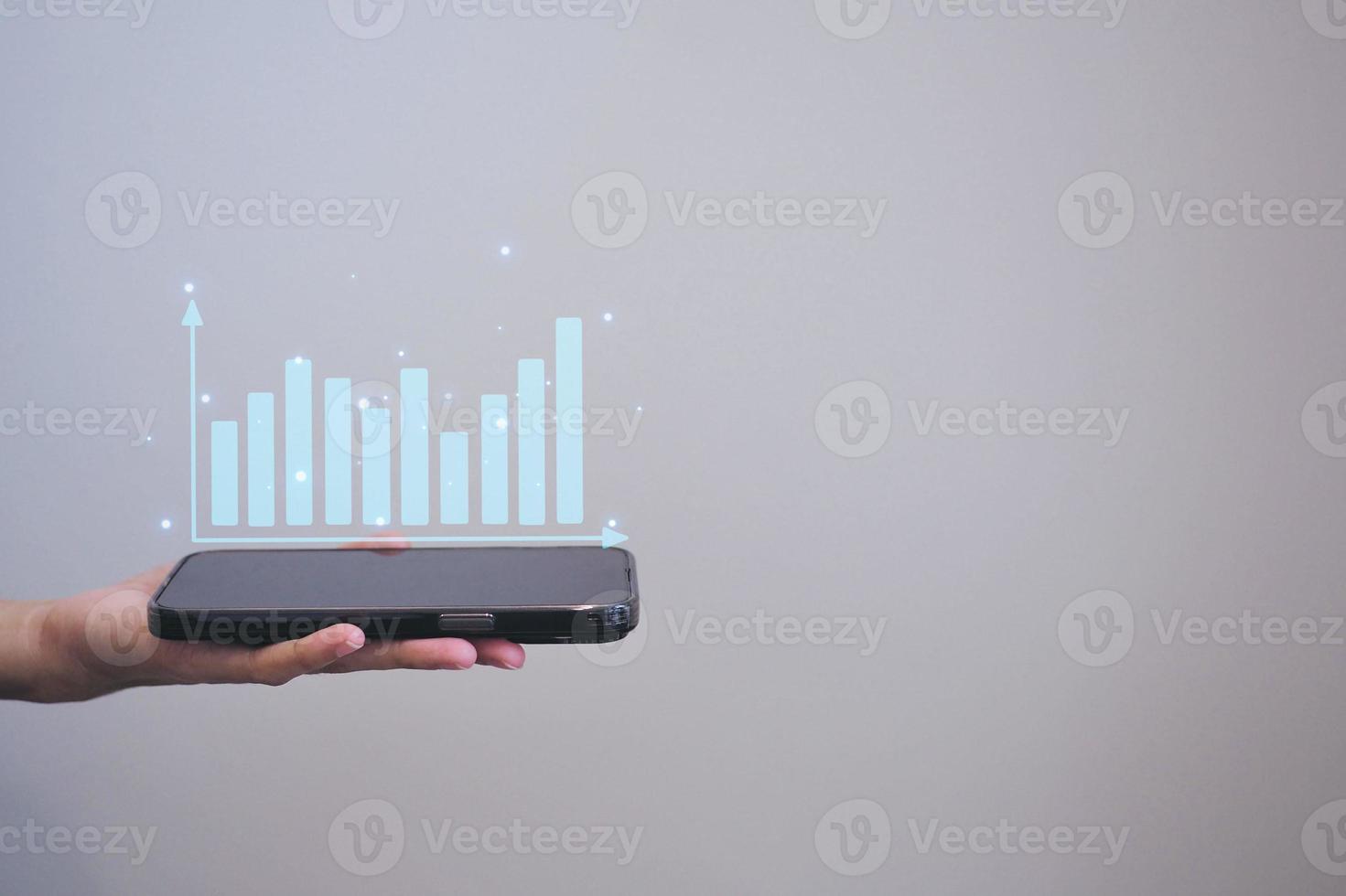 zakenman Holding smartphone of mobiel telefoon met diagram bedrijf economisch groei concept. foto