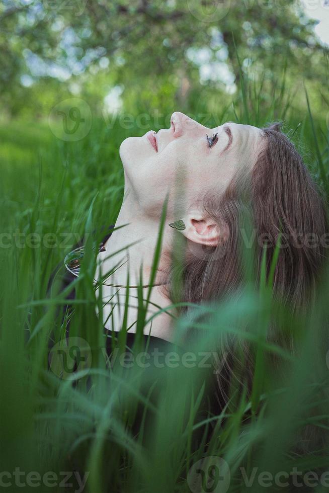 dichtbij omhoog vrouw in hoog gras op zoek omhoog Bij lucht portret afbeelding foto