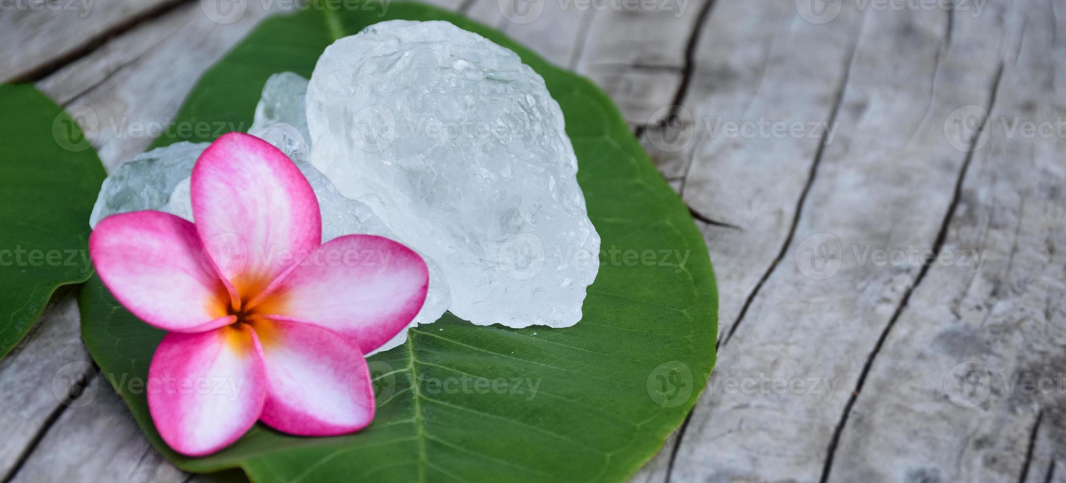 aluin kubussen Aan keramisch pot en plumeria bloemen achtergrond, concept voor kruid, lichaamsverzorging, huidverzorging, glashelder, spa, behandeling, ziekte bescherming en beschermen oksel geur. foto