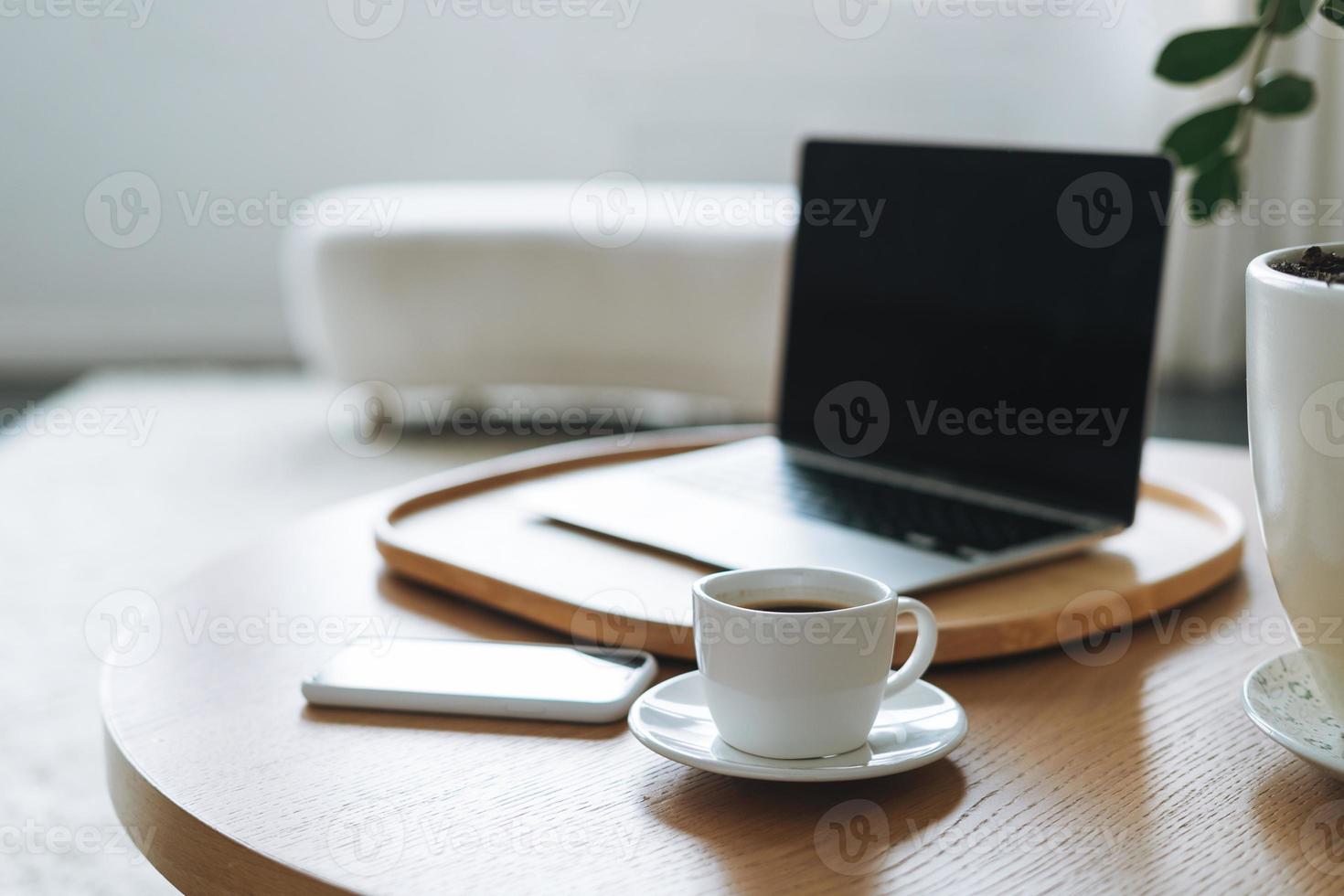 werken plaats met kop van koffie, Open laptop Aan houten tafel in kantoor kamer, bedrijf interieur foto