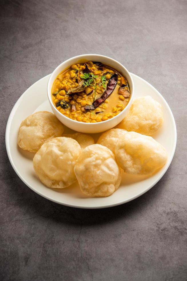 luchi choler dal of gebakken brood gemaakt van meel geserveerd langs met curried chana of Bengalen gram foto