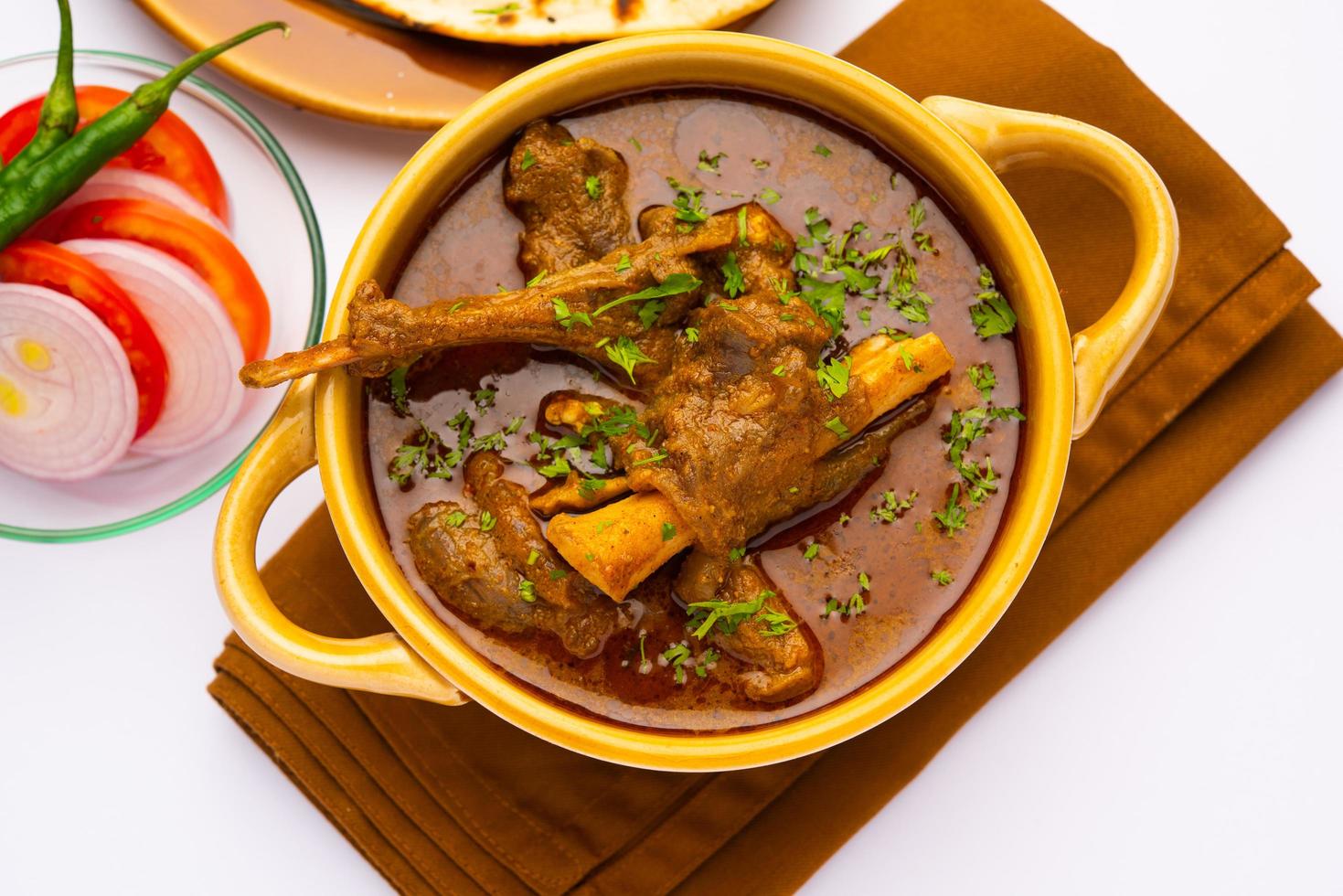 Indisch stijl schapenvlees of godverdomme masala of Indisch lam vlees rogan josh geserveerd met naan foto