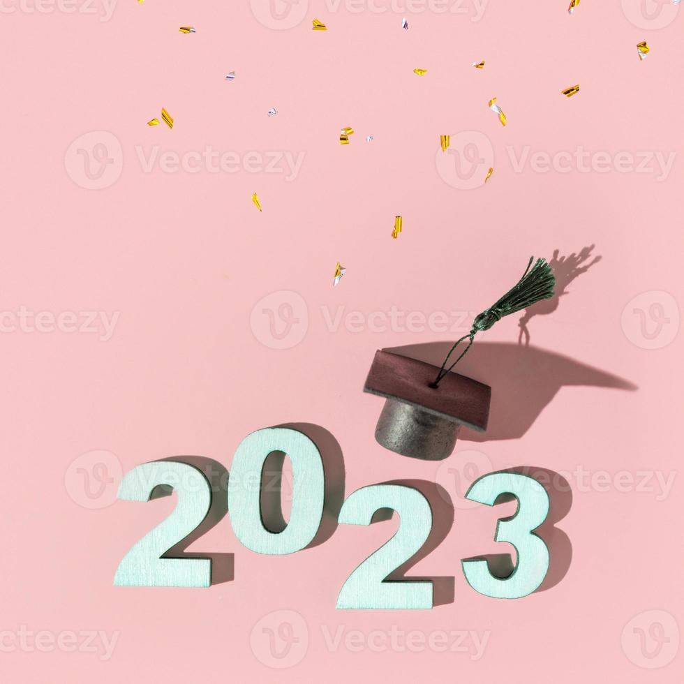 klasse van 2023 concept. getallen 2023 met zwart afgestudeerd pet Aan gekleurde achtergrond foto