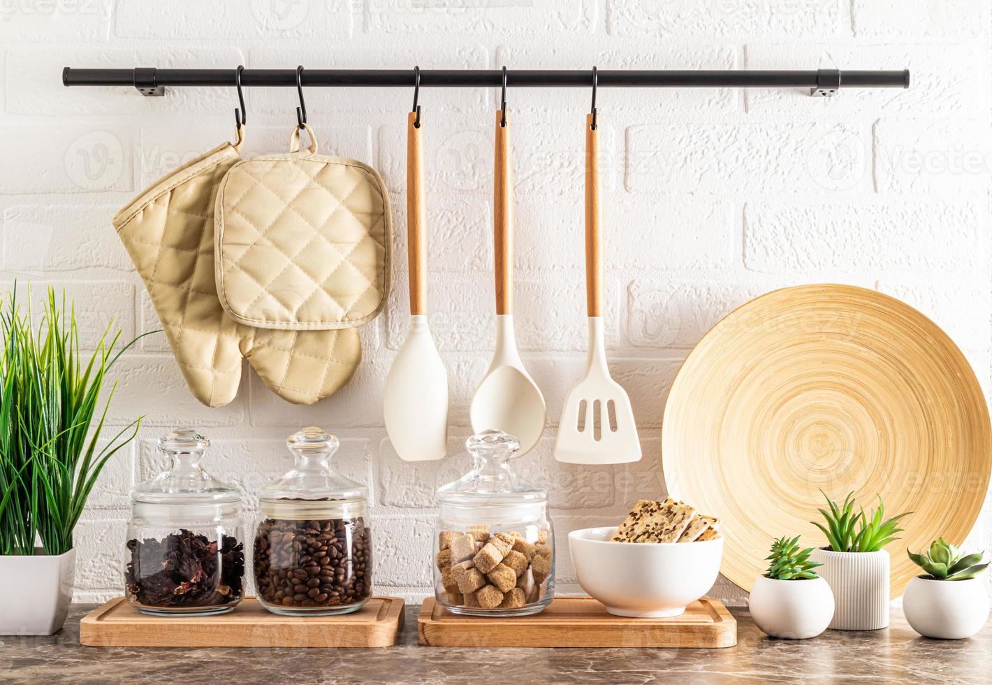 voorkant visie van de keuken aanrecht een deel met een reeks van glas potten voor opslag, een kom met biscuits en ingemaakt kamerplanten. steen muur met traliewerk. foto