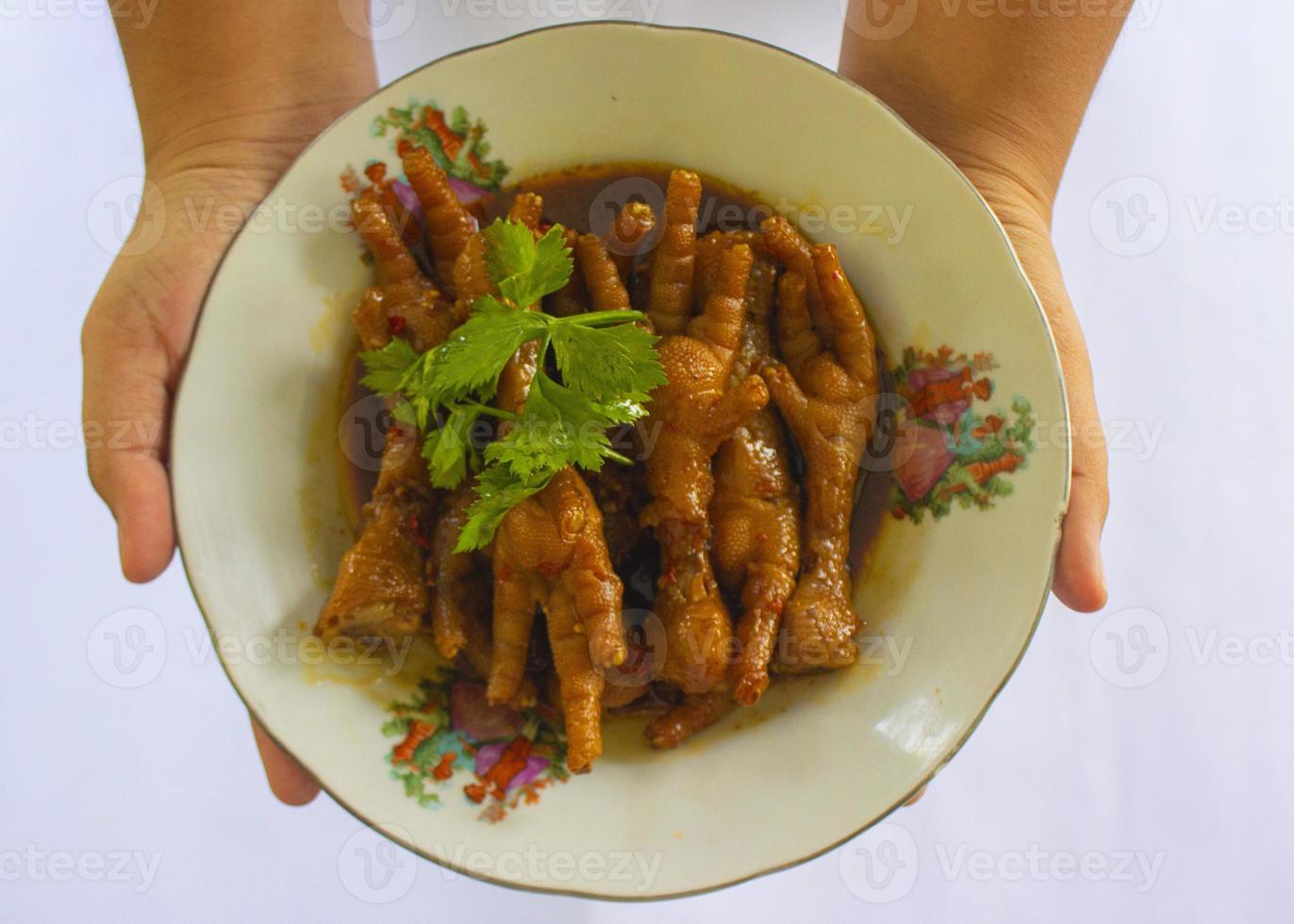pittig kip voeten met selderij, Chili, ui, knoflook geserveerd met een wit bord geïsoleerd van een zwart achtergrond. foto