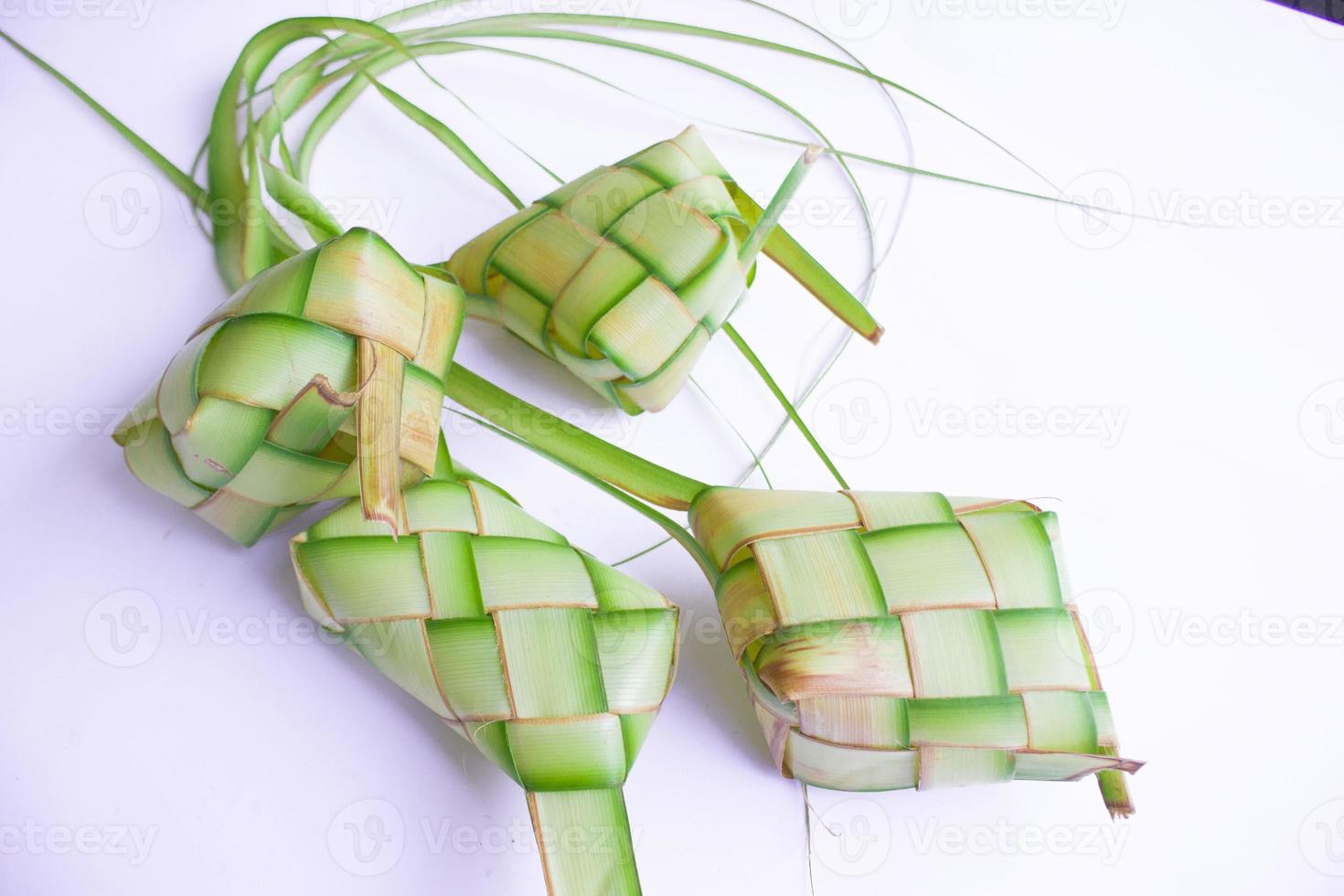 ketupat in aardewerk bord geïsoleerd Aan wit achtergrond. ketupat rijst- knoedel is voedsel geserveerd wanneer idhul fitri eid mubarak in Indonesië, gemaakt van rijst- verpakt in jong kokosnoot bladeren janur foto