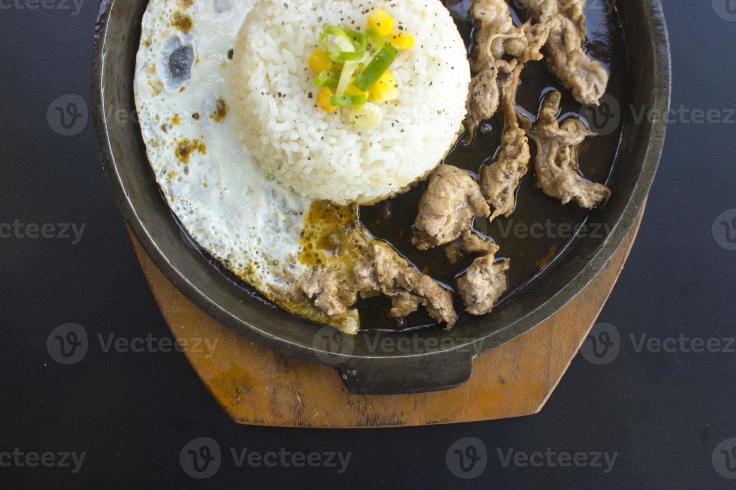 ontbijt met rijst, gebakken ei en vlees of rundvlees met garneer maïs en prei dichtbij omhoog heet bord geïsoleerd Aan wit achtergrond foto