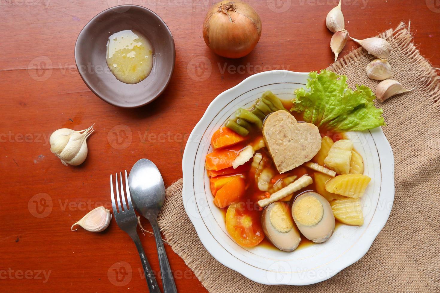 selat solo is traditioneel salade voedsel van Indonesië. gemaakt van hard gekookt eieren, gekookt kikkererwten, gekookt wortels, hasj bruin en sla, steak of bistik. geserveerd Aan hout tafel foto