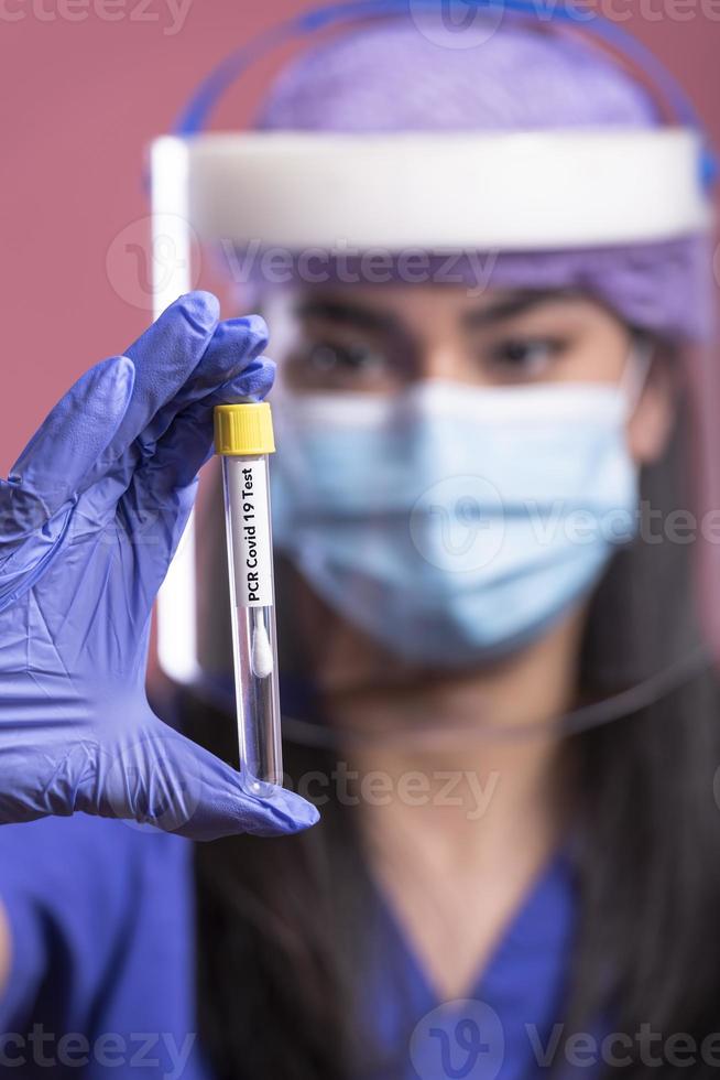 vrouw dokter vervelend gezicht schild en ppe pak voor coronavirus het uitbreken Holding vaccin en covid testen. concept van covid-19 foto