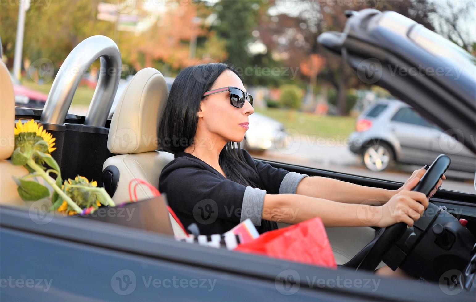 gelukkig mooi vrouw het rijden een sport- auto in de stad foto