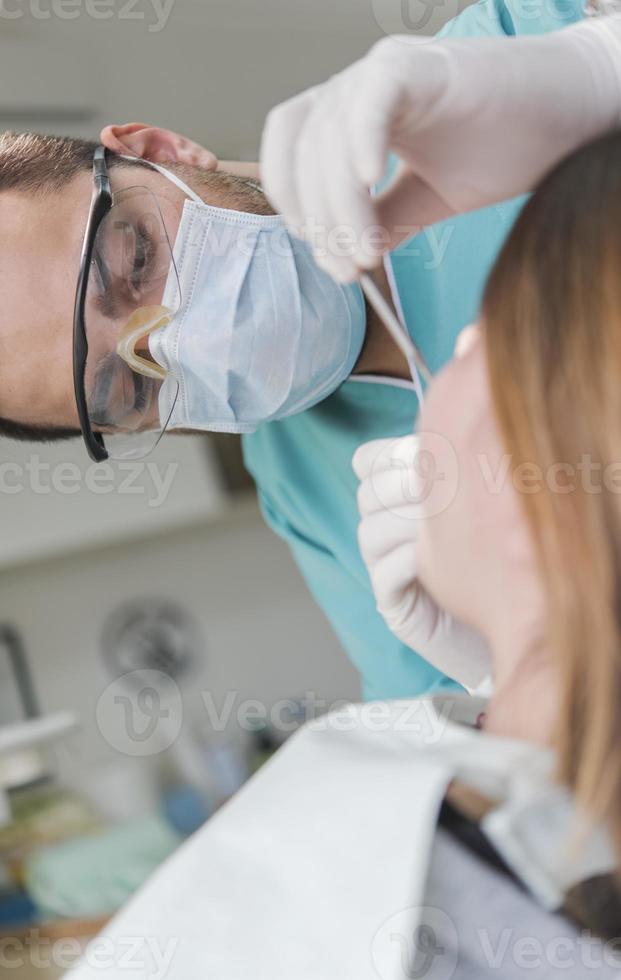 tandarts genezen patiënten tanden vulling holte. tandarts werken met professioneel uitrusting in kliniek. foto