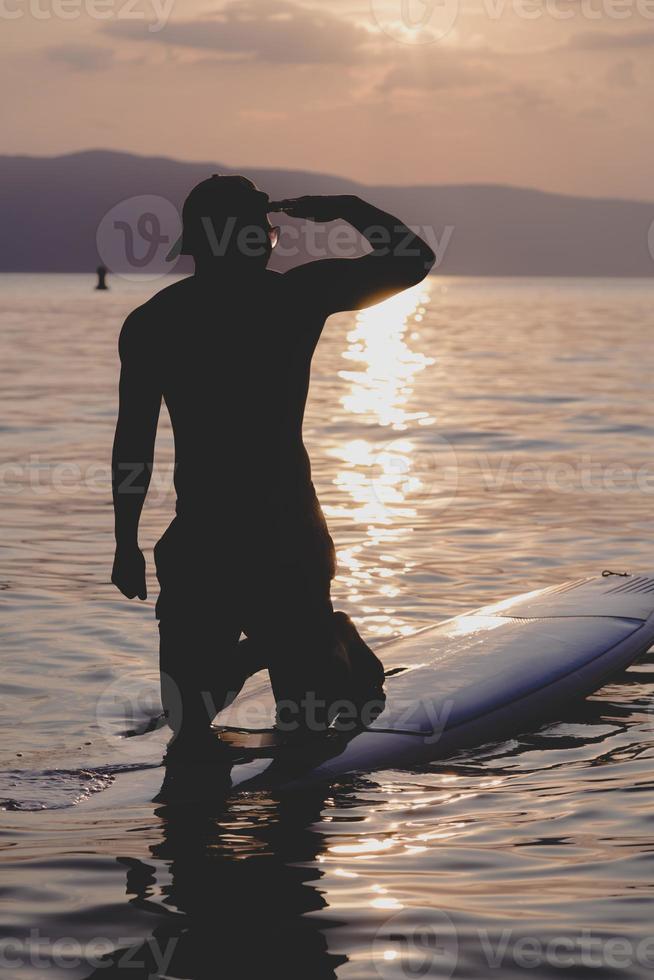 knap sportief Mens is kajakken Aan zonsondergang foto