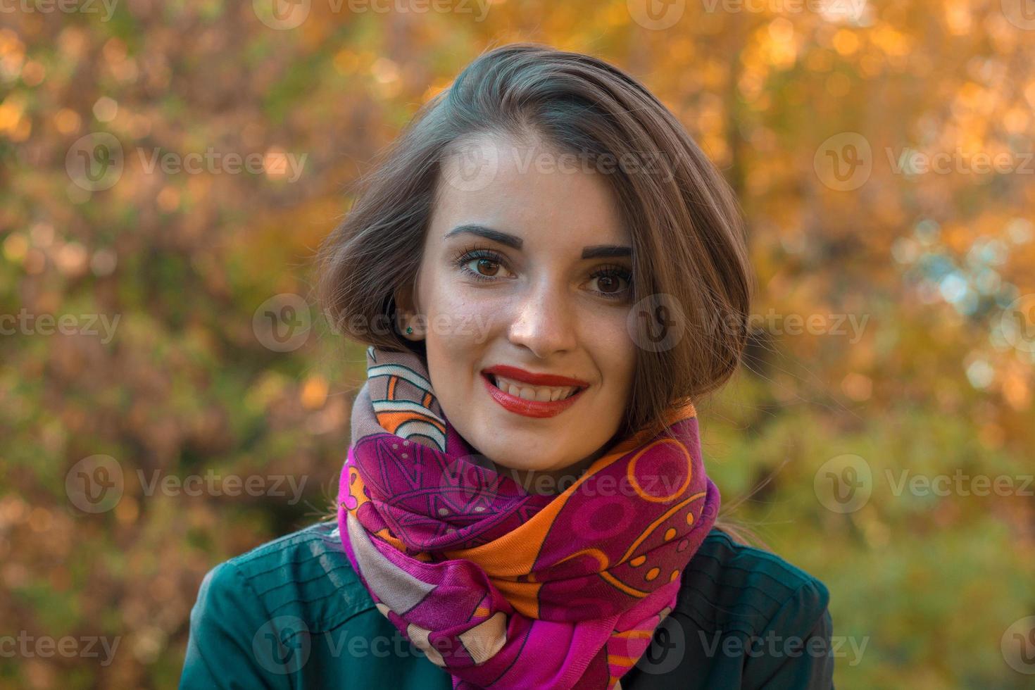 portret van een schattig jong meisje in sjaal en rood lippen welke glimlacht foto