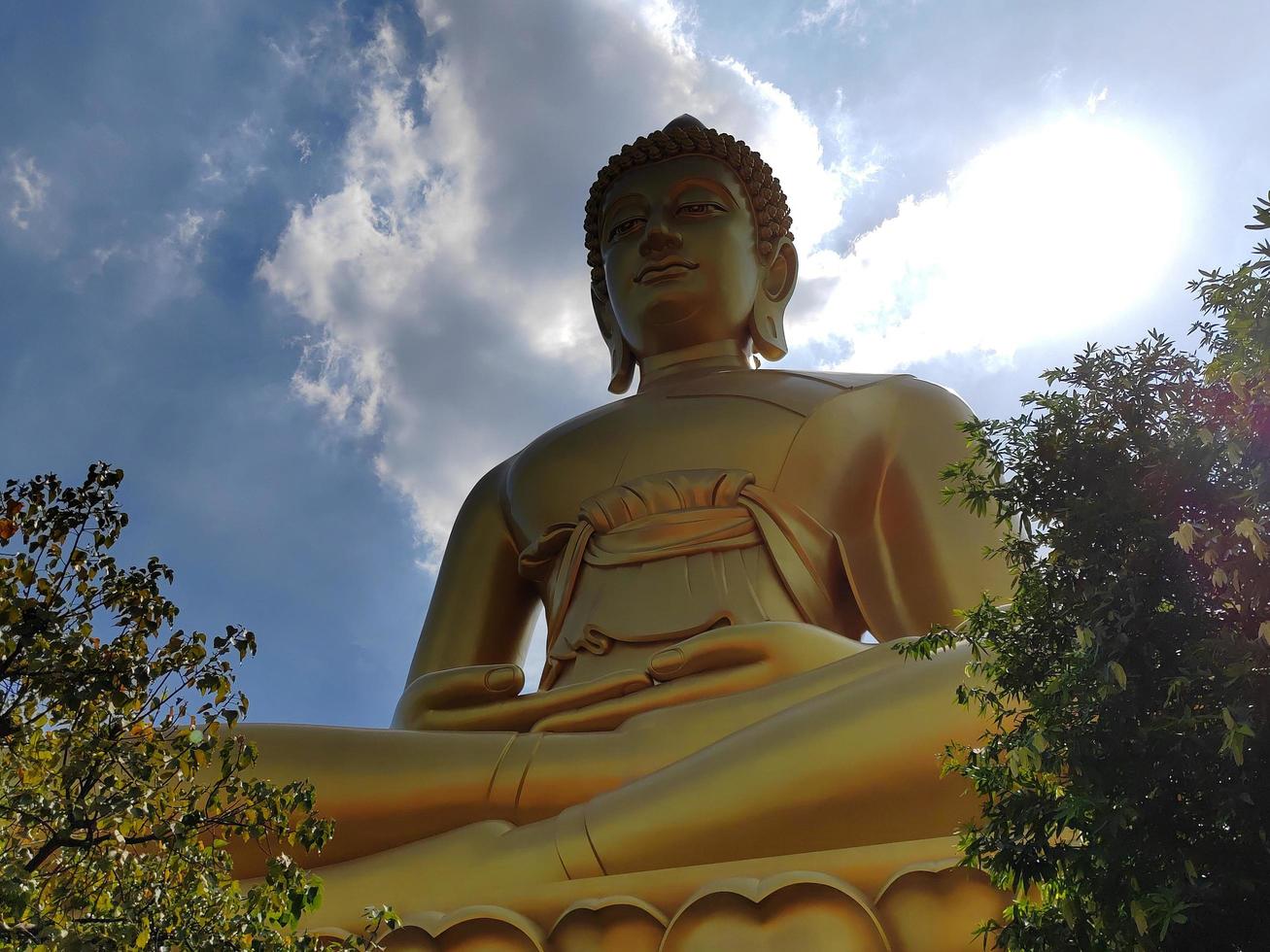 gouden groot Boeddha standbeeld phra Boeddha dhammakaya de P mongkol in wat pak naam phasi Charoen tempel. zonlicht lucht en wolk achtergrond foto