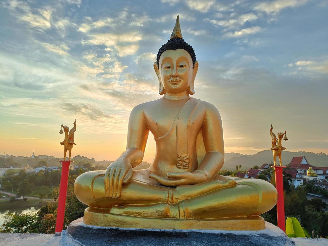 gouden Boeddha standbeeld tegen zonsondergang lucht in Thailand tempel foto