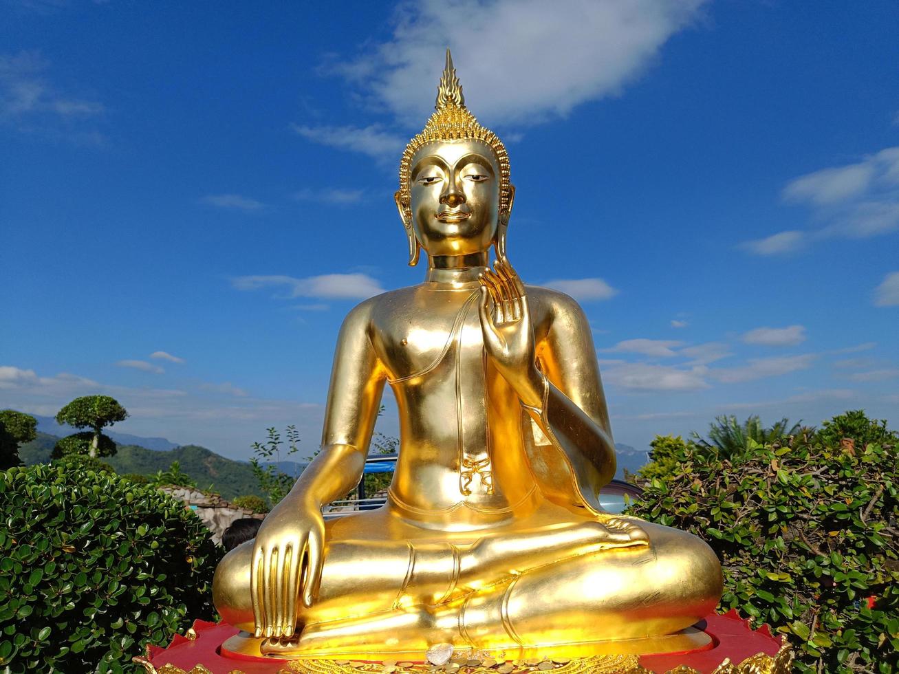 gouden Boeddha standbeeld tegen blauw lucht en wolken in Thailand tempel, wat phra dat phasornkaew khao kho wijk, phetchabun provincie foto