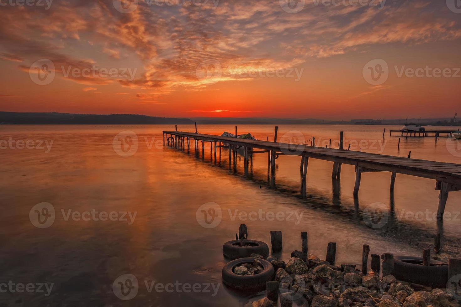 verbijsterend zonsondergang Bij de haven met houten pier foto