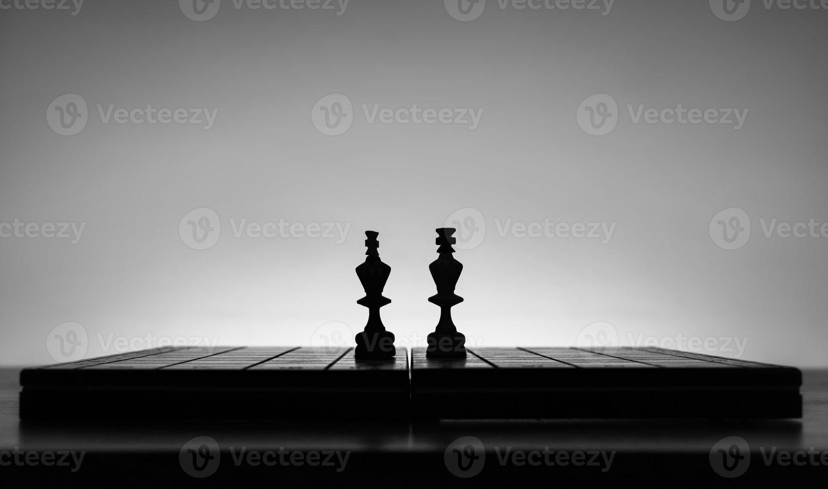 schaak bord met schaak stukken silhouetten Aan wit achtergrond. concept van bedrijf ideeën, wedstrijd en strategie ideeën. zwart en wit klassiek kunst foto. koningen strijd in midden. foto
