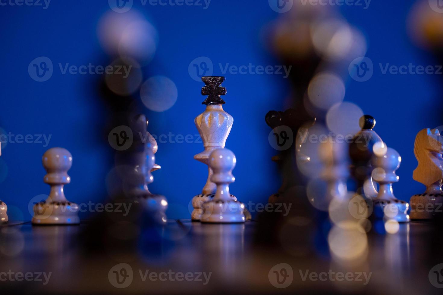 schaak bord met schaak stukken Aan blauw achtergrond. concept van bedrijf ideeën en wedstrijd en strategie ideeën. wit koning dichtbij omhoog. foto