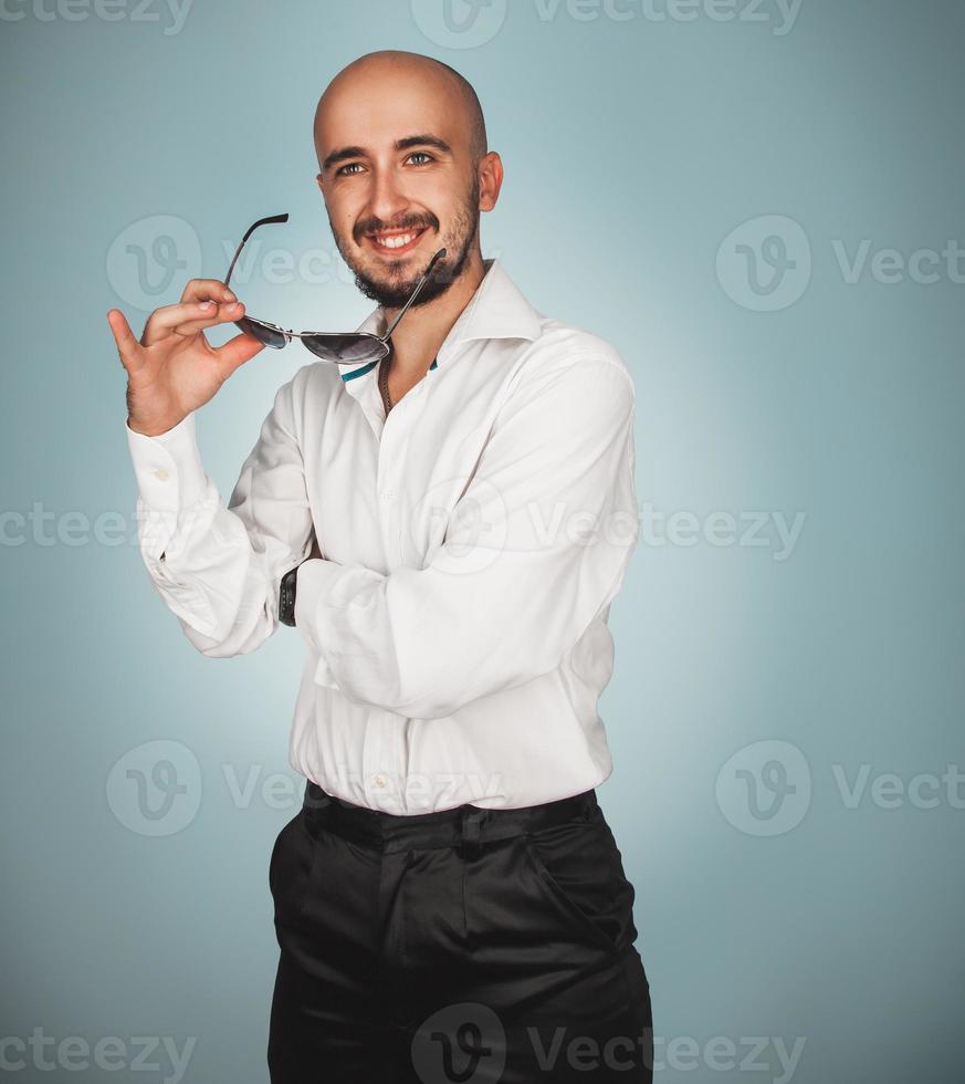 Mens met zonnebril in studio glimlachen foto