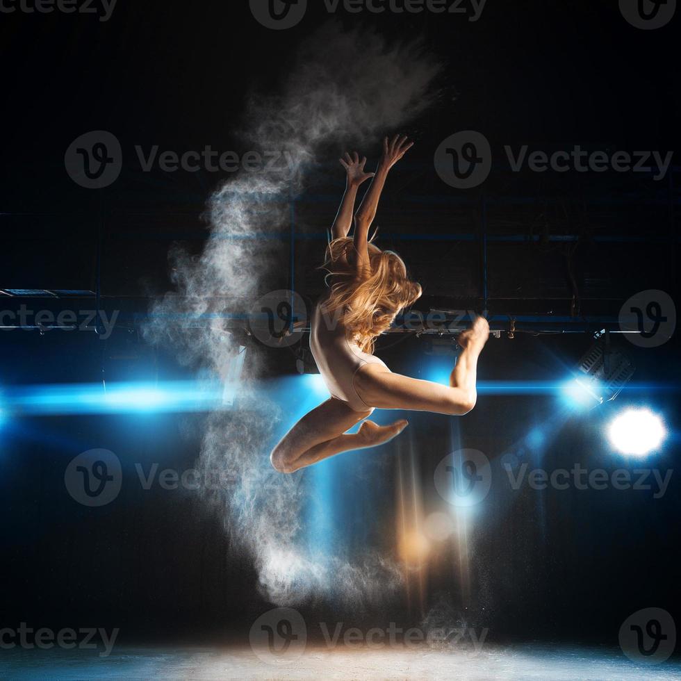blond volwassen ballerina in springen Aan stadium van theater foto