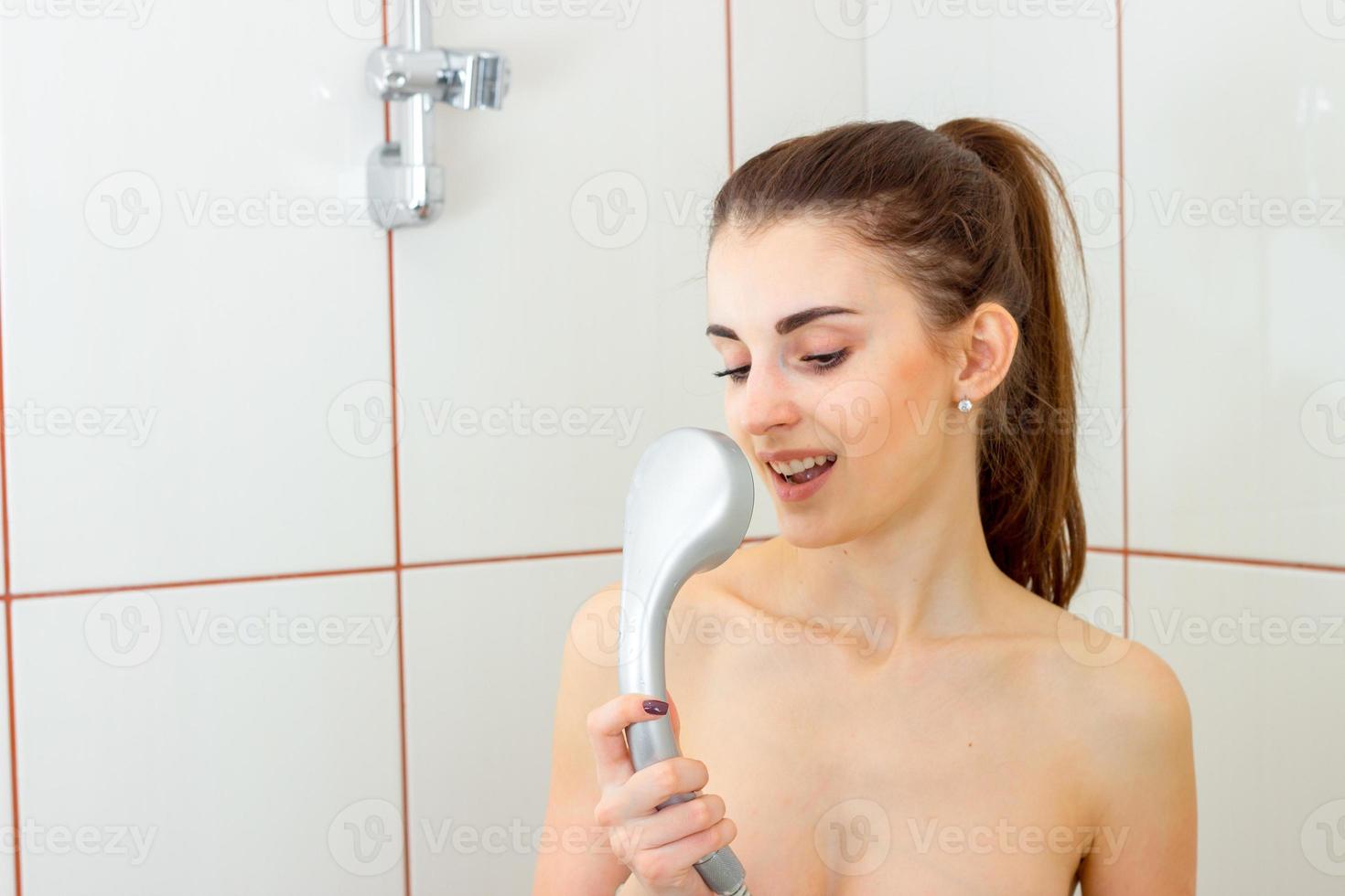 jong vrouw in de douche het zingen in de menger foto