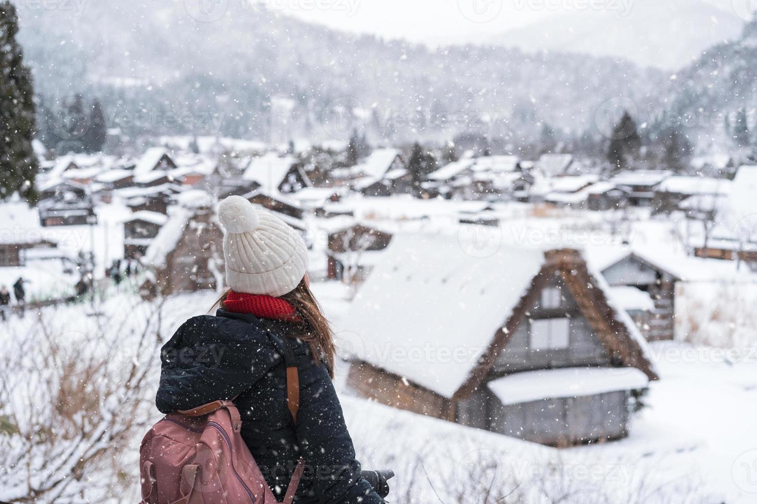 jong vrouw reiziger op zoek Bij de mooi UNESCO erfgoed dorp in de sneeuw in winter Bij shirakawa-go, Japan foto