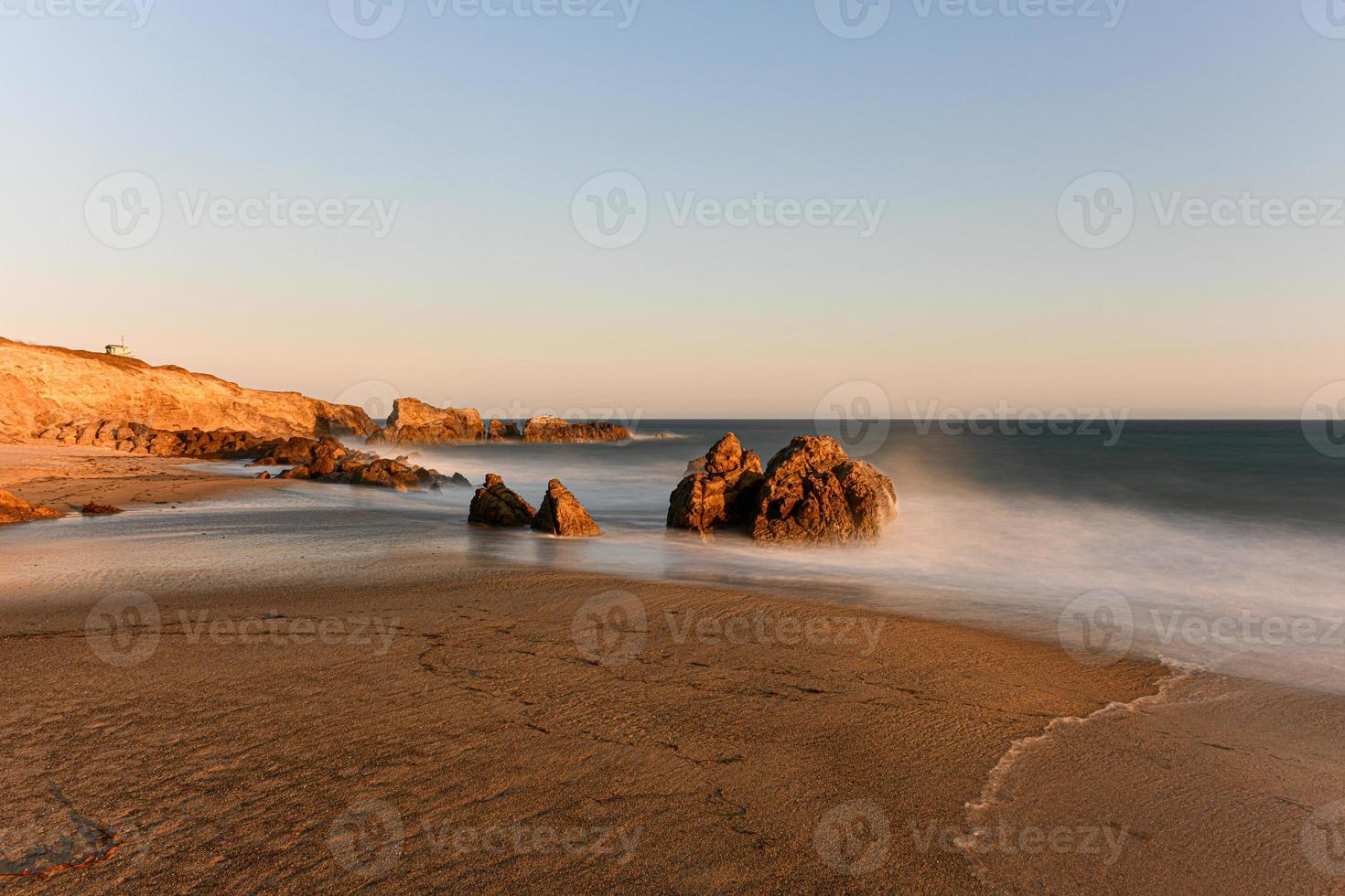 verbijsterend lange blootstelling visie van glad golven crashen in rots formaties Bij zonsondergang, sequit punt, Leo carrillo staat strand, malibu, Californië foto