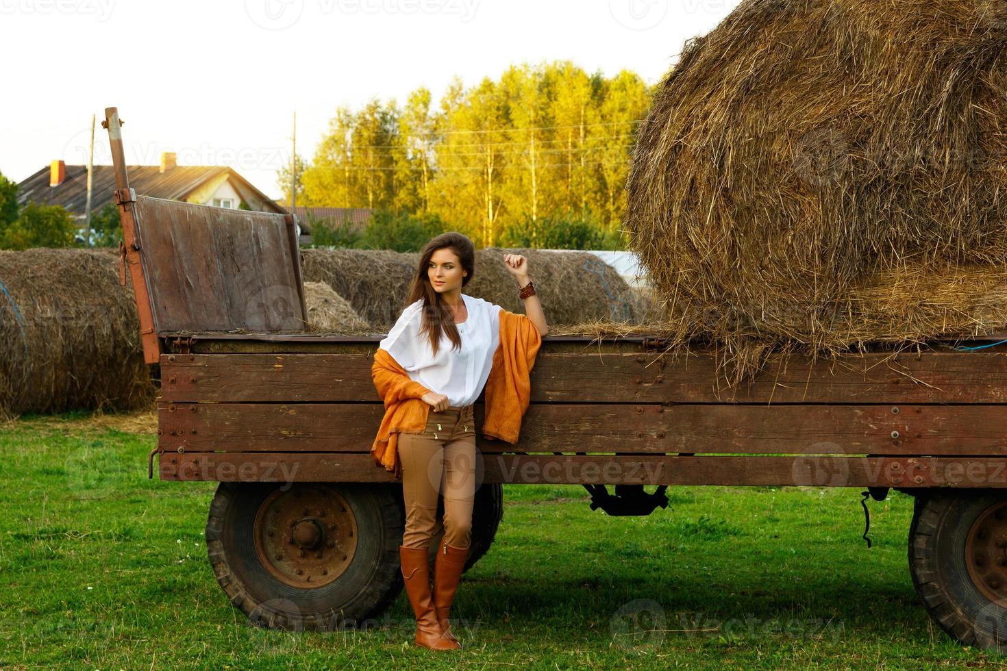 jong vrouw en vervoer met een hooibergen in de dorp foto