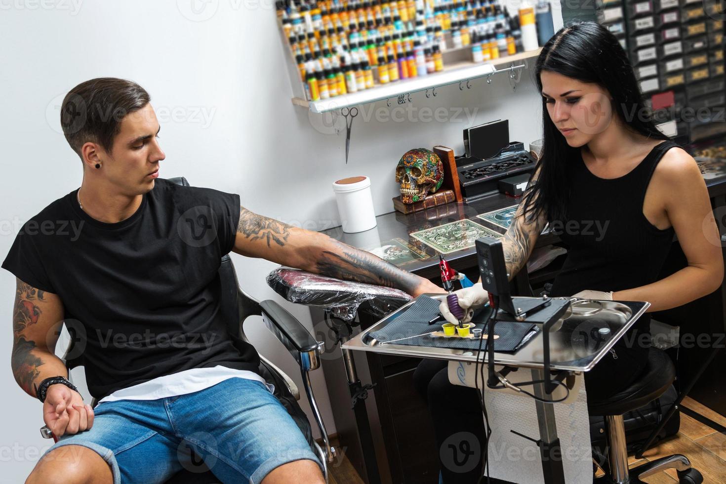 tatoeëren artiest gedurende haar werk foto