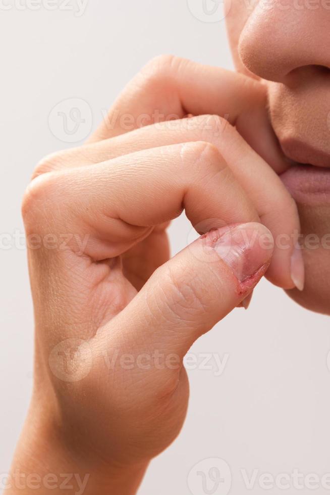 detailopname van een vrouw mond bijten haar vingers foto