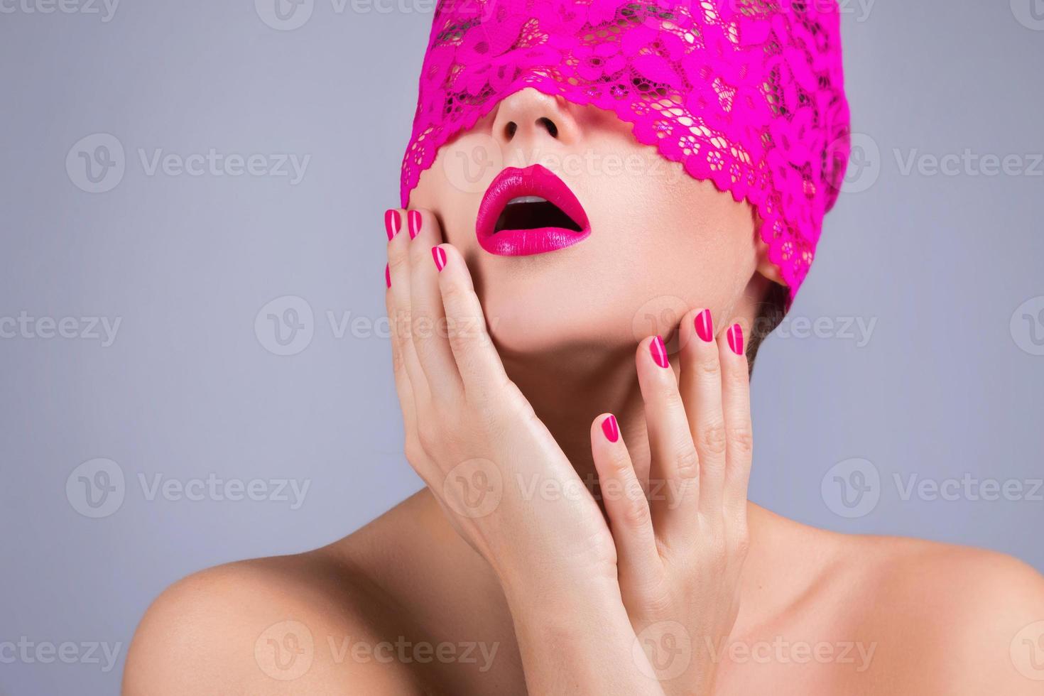 vrouw met een roze blinddoek Aan haar gezicht foto