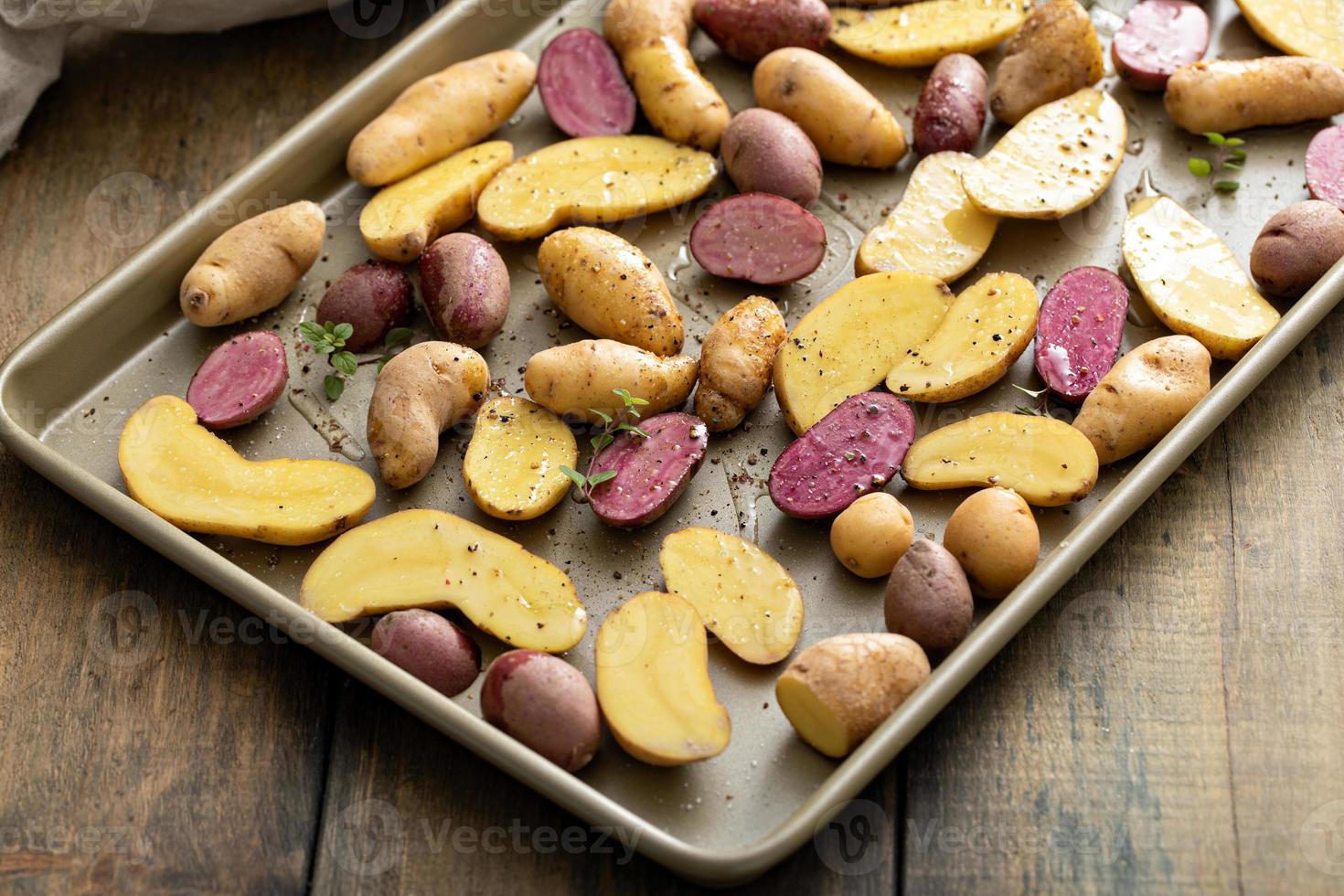 geel en Purper vingeren aardappelen Aan een bakken vel foto