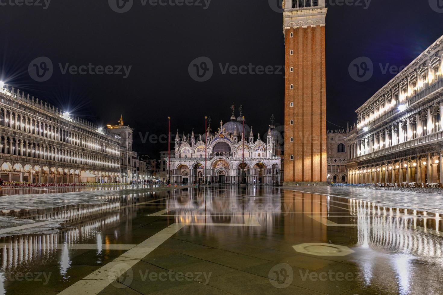 heilige mark's plein in Venetië Italië Bij nacht met reflecties in de water. foto